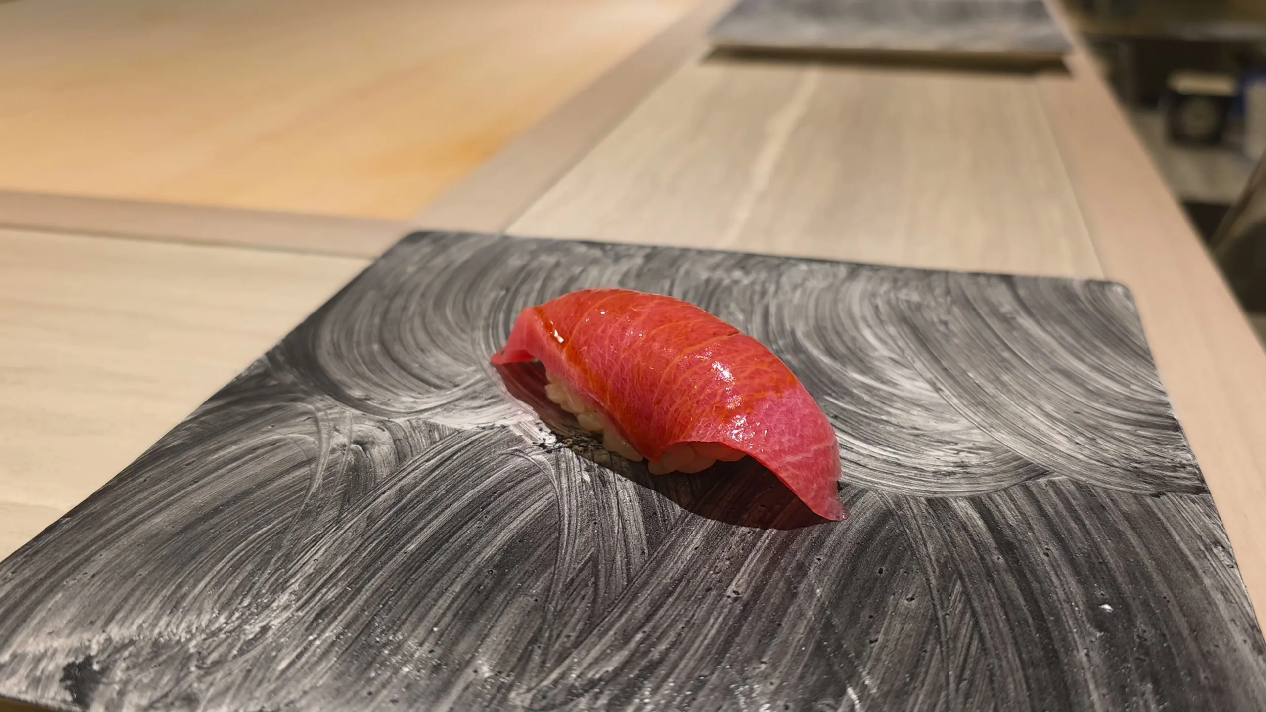 Chu-toro nigiri on a brushed slate plate